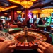 Players thrill at the BIGBET88 roulette table in a luxurious casino setting filled with vibrant colors and excitement.